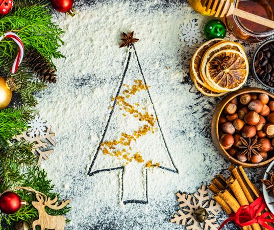 Top view of Christmas tree outline in flour with tinsel brown sugar