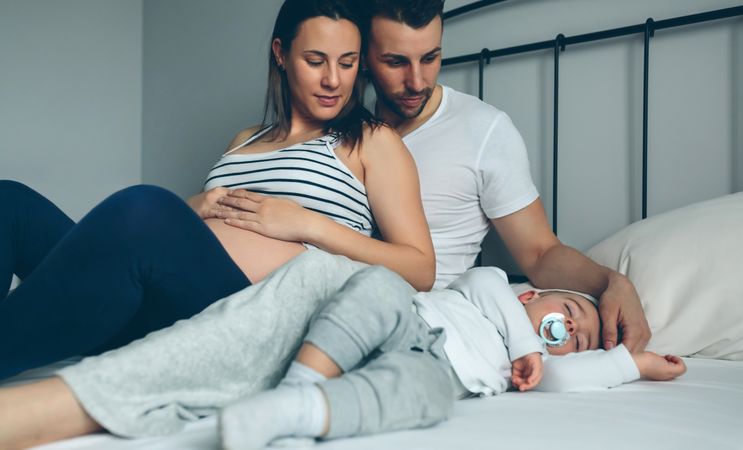 Pregnant woman with her husband looking son