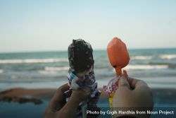 An ice cream cone in each hand looking out to the beach 5qevK5