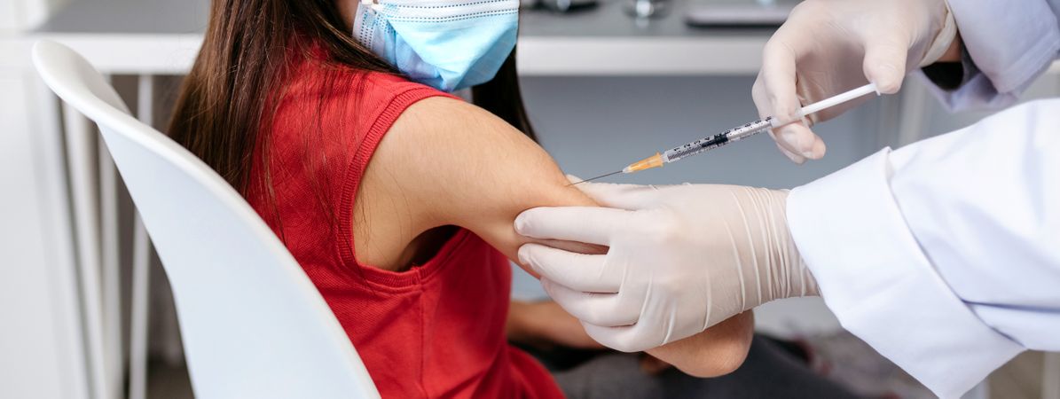 Girl receiving coronavirus vaccine at doctor's office