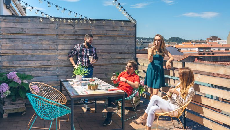 Friends talking and drinking at a party on a terrace