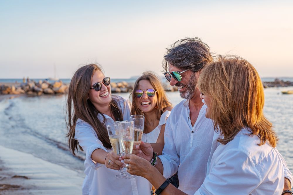 Happy family drinking wine on beach