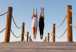 Women posing in air on footbridge