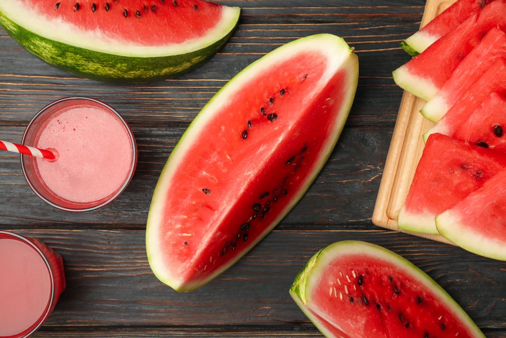 Composition with watermelon slices and juice on wooden background. Summer fruit