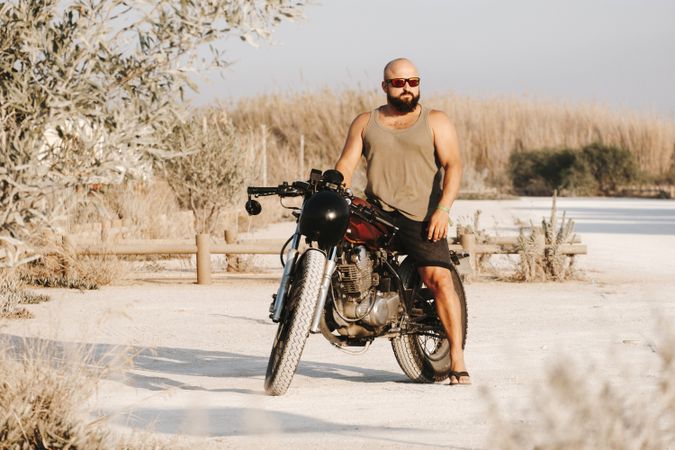 Serious male driving motorcycle in forest