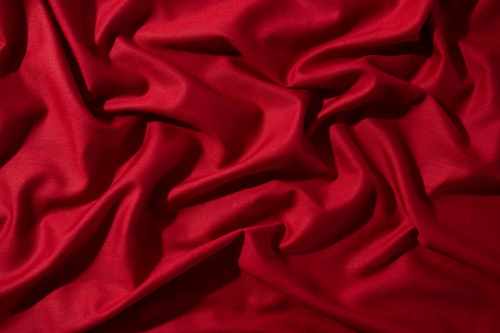 Crumpled wavy Red silky fabric background texture.