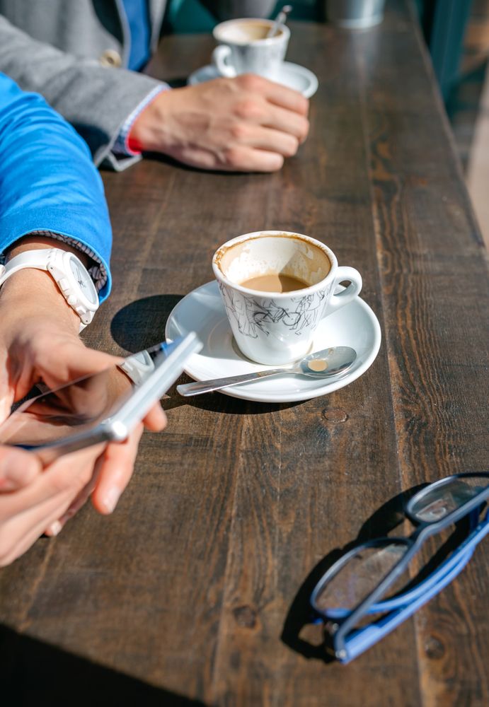 Hands of business woman and man having coffee