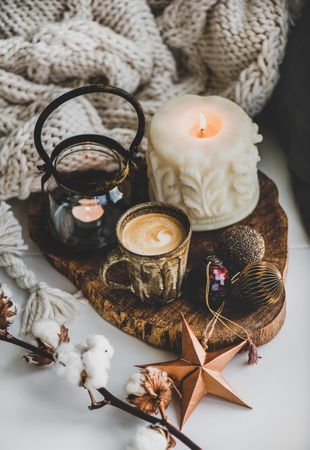 Coffee, candles, festive decorations against woolen blanket