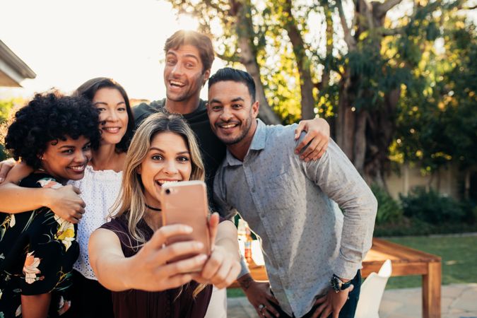 Group of people at housewarming party taking selfie