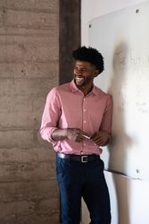 Man standing and laughing at a dry erase board