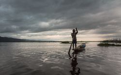Shan, Myanmar - June, 25 2012: Anonymous fisherman standing on boat