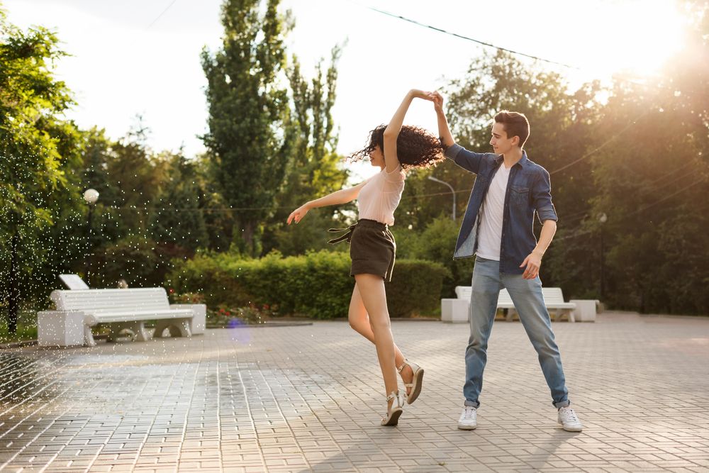 Cute teenage couple in love spinning while dancing
