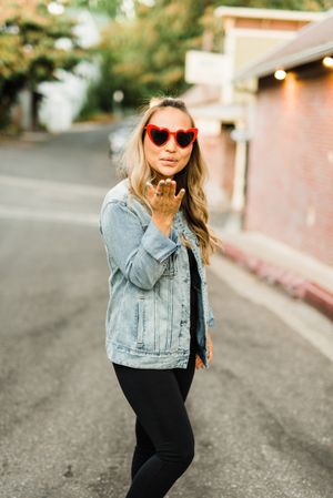 Woman with sunglasses blowing a kiss