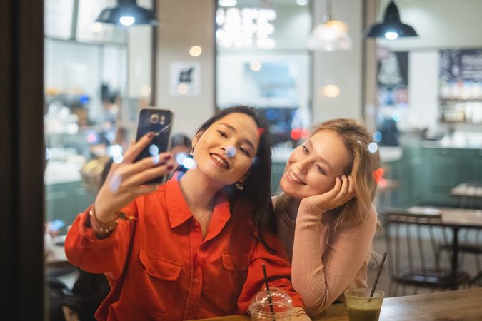 Young women taking selfie in cafe