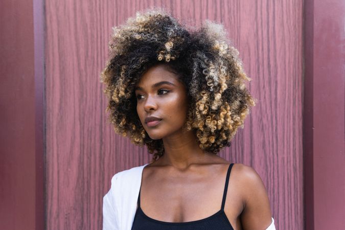 Stylish Black woman standing near colorful door