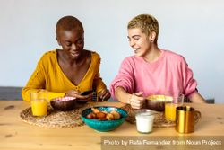 Two multi-ethnic women having breakfast together at home 4m8AB5