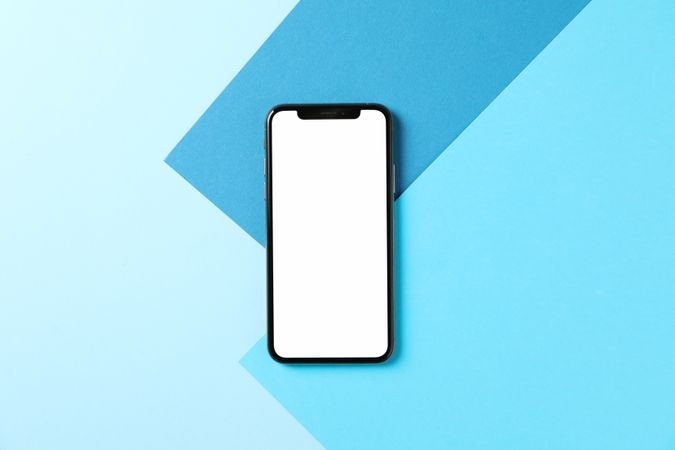 Phone with empty screen on three tone background, top view