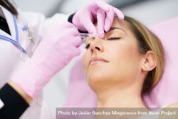 Woman having her upper nose injected 5zDgmb