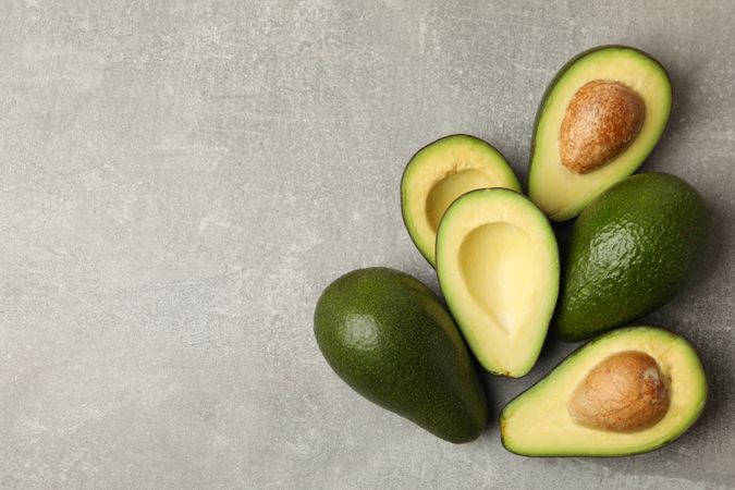 Ripe fresh avocado on gray background, space for text