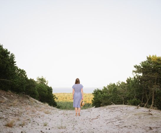 Young woman standing among pine trees