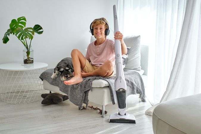 Cheerful boy taking break in housework