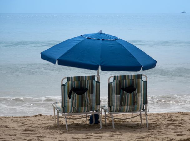 Empty beach chairs with umbrellas on sandy beach