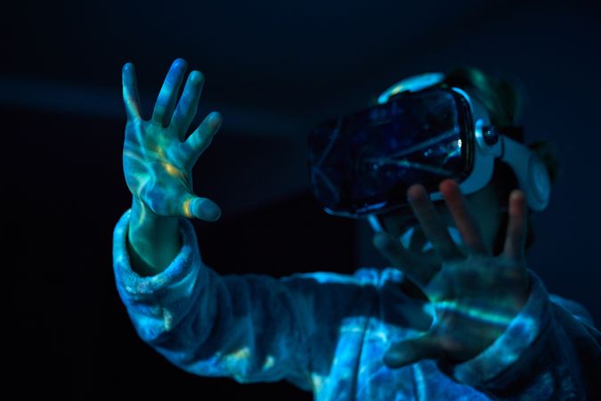 Anonymous child touching imaginary screen in VR glasses