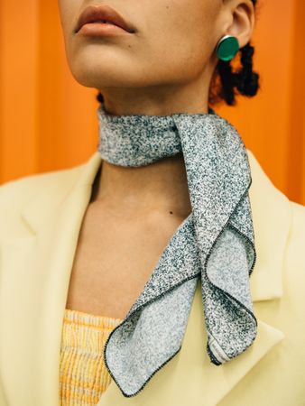 Cropped image of woman wearing yellow blazer and gray scarf
