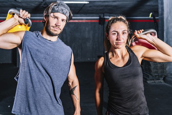 Muscular fellows with kettle bells looking at camera