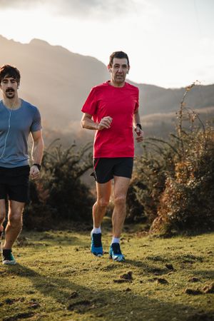 Sportive men running in mountains