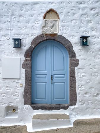 Patmian blue door with overhead stone carving