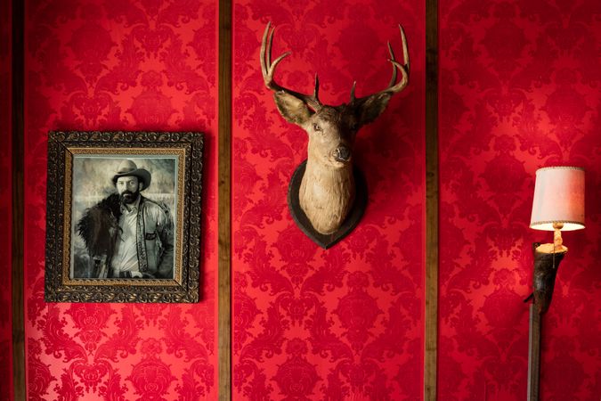 Mounted deer head and old western portrait on red wall, Old Trail Town, in Cody, Wyoming