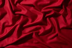 Crumpled wavy Red silky fabric background texture.