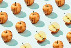 Half apple in row with whole apples