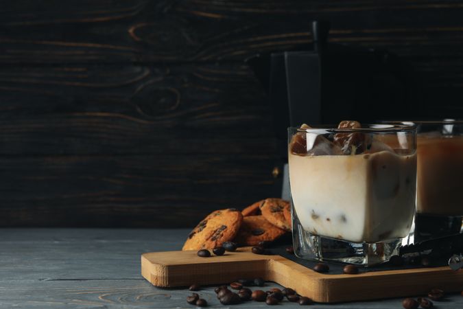 Composition with ice coffee and cookies on wooden background