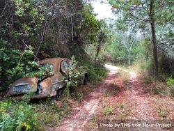 Rusty automobile on offroad path 0gXGoX