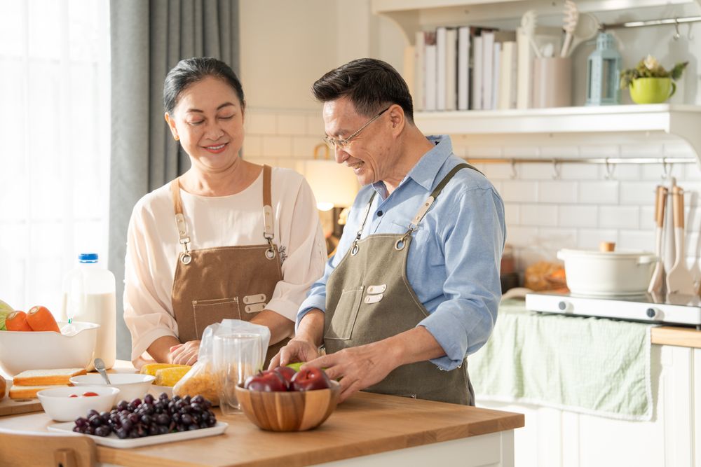 Asian older couple cooking breakfast in the kitchen