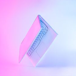 Laptop painted in light colored paint with gradient purple and blue holographic color lights