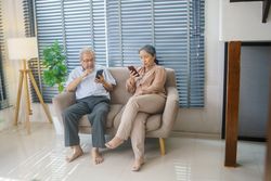 Older couple using smartphones on couch