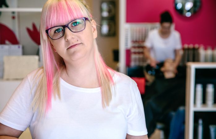 Portrait of hairdresser with pink hair in salon