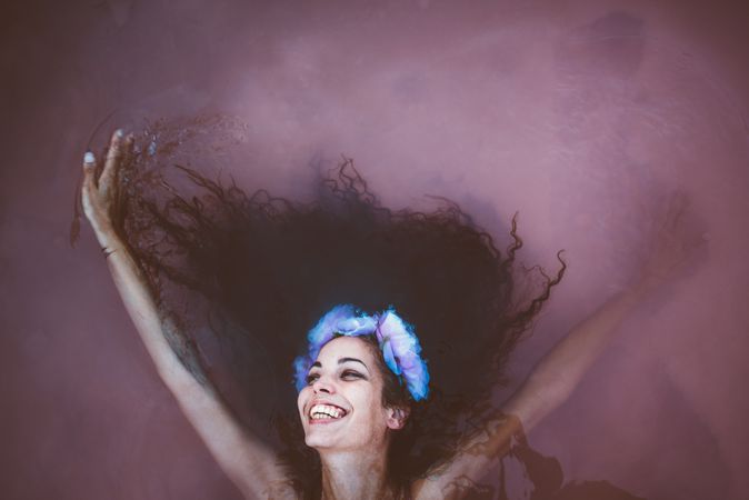 Woman with wreath lying in water