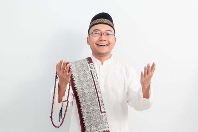 Asian Muslim man smiling doing greeting pose during Ramadan