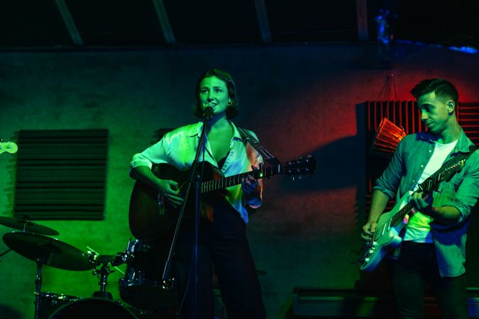 Musicians In Stage With Colorful Lights Performing In A Live Concert