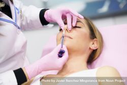 Woman having the base of her nose injected 5aGYvb