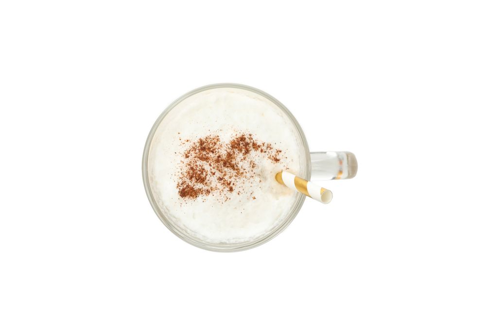 Glass cup of latte isolated on neutral background