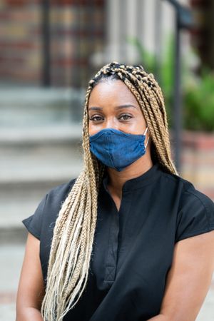 Close up portrait of doctor with blonde braids wearing mask and scrubs