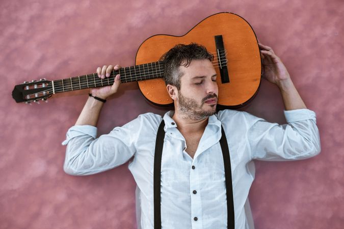Man resting in water with guitar at seaside