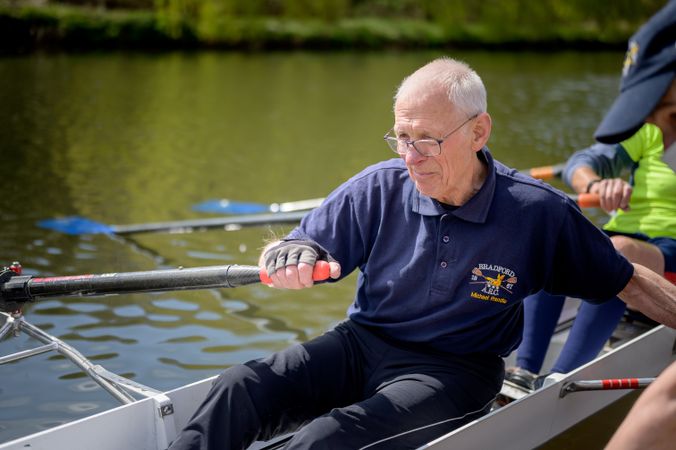 Man rowing in river with team