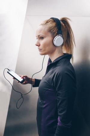 Woman with sportswear listening to music with headphones
