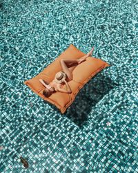 Woman on inflatable mattress in swimming pool